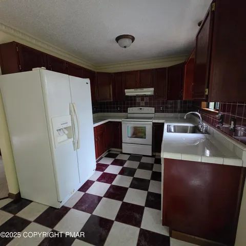 a kitchen with a refrigerator sink and cabinets