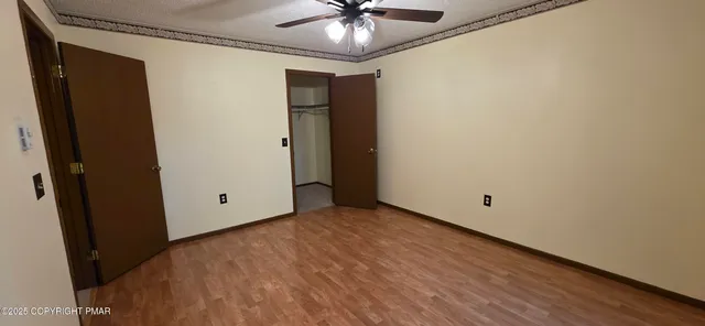a view of an empty room with a ceiling fan