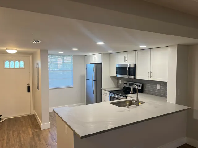 a kitchen with kitchen island a sink appliances and cabinets