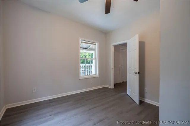 an empty room with wooden floor and window