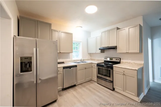 a kitchen with stainless steel appliances granite countertop a stove a refrigerator and a refrigerator