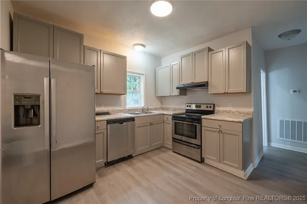 a kitchen with cabinets appliances and a window