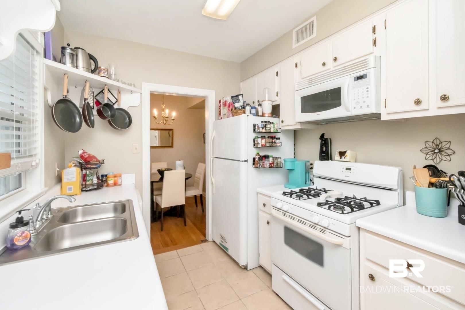 214 Upham Street, Unit 17C Mobile, AL 36607 - Photo 22 of 32 Kitchen featuring white appliances, light countertops, white cabinets, a chandelier, and light tile patterned floors
