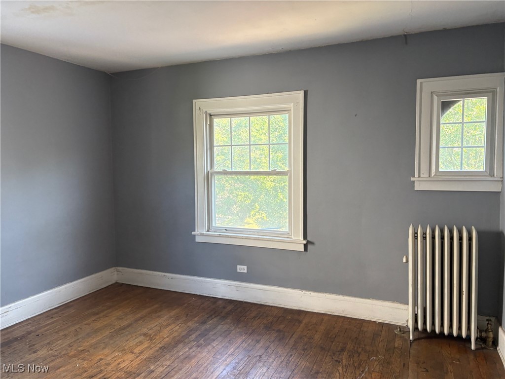 3258 Berkshire Road Cleveland, OH 44118 - Photo 15 of 23 Empty room with radiator and dark wood-style floors