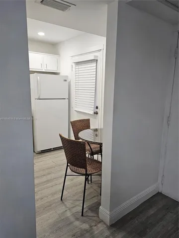 a kitchen with a refrigerator a table and chairs