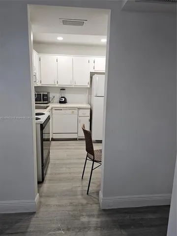 a view of kitchen with wooden floor and electronic appliances