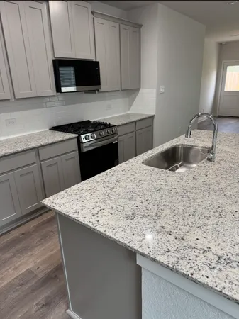 a kitchen with kitchen island sink stove and cabinets
