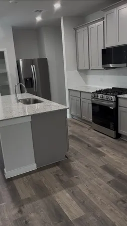 a kitchen with granite countertop a stove and a sink