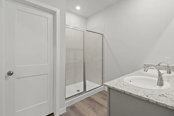 a bathroom with a granite countertop sink and shower