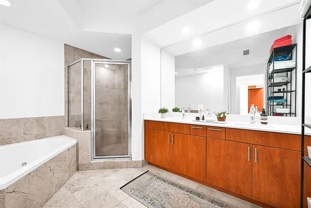 a spacious bathroom with a tub shower and sink