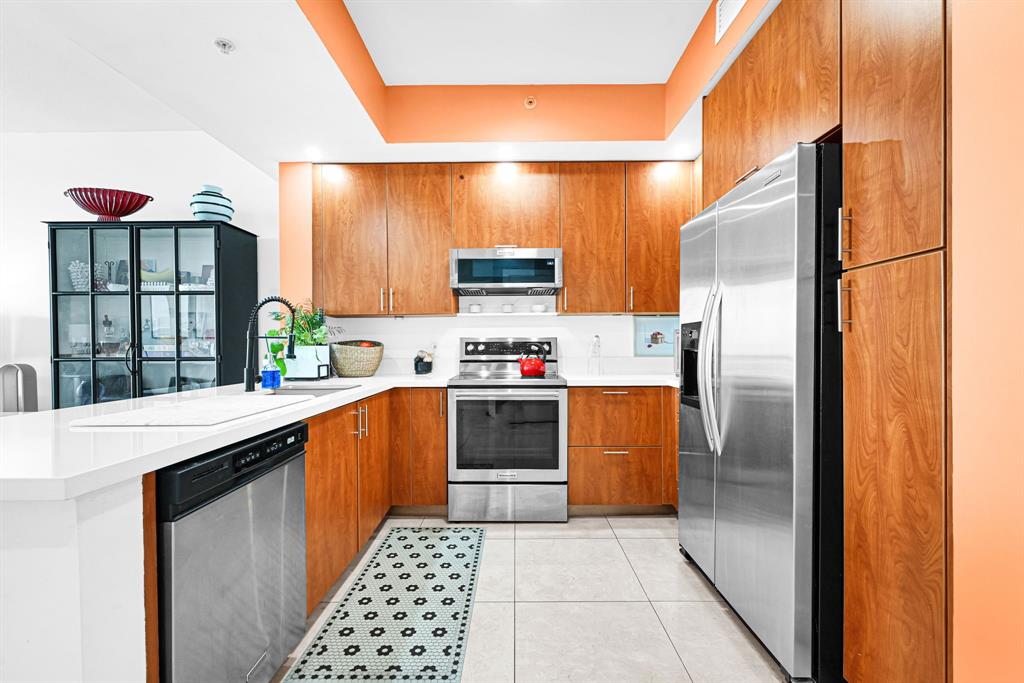 315 Northeast 3rd Avenue, Unit 1008 Fort Lauderdale, FL 33301 - Photo 5 of 52 a kitchen with stainless steel appliances a refrigerator and a stove