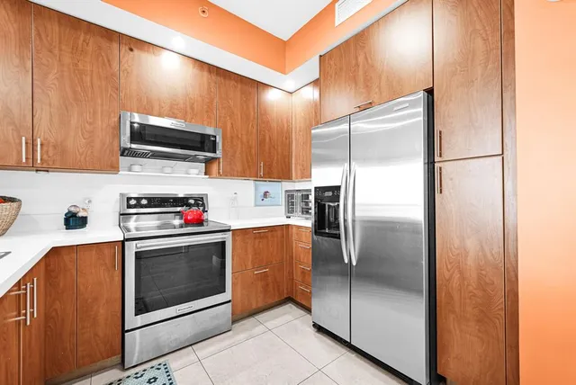 a kitchen with stainless steel appliances granite countertop a refrigerator and a stove top oven