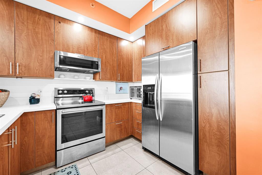 315 Northeast 3rd Avenue, Unit 1008 Fort Lauderdale, FL 33301 - Photo 6 of 52 a kitchen with stainless steel appliances granite countertop a refrigerator and a stove top oven