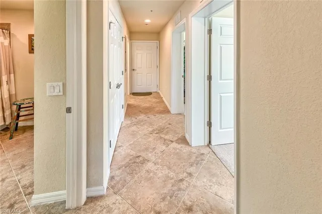a view of a hallway with wooden floor and a bathroom
