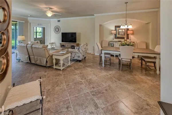 a living room with furniture a flat screen tv and a dining table