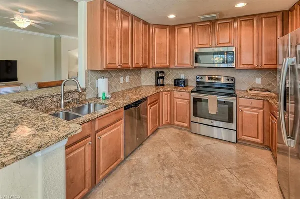 a kitchen with stainless steel appliances granite countertop a sink stove and refrigerator