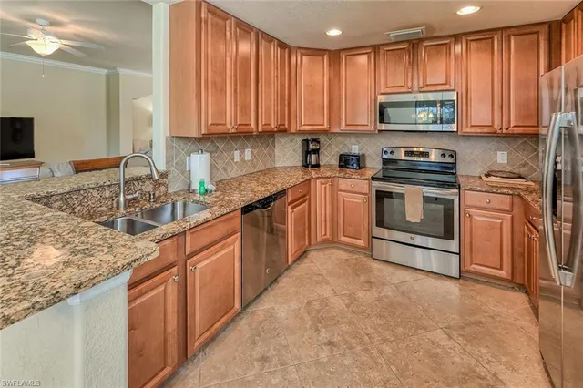 a kitchen with stainless steel appliances granite countertop a sink stove and refrigerator