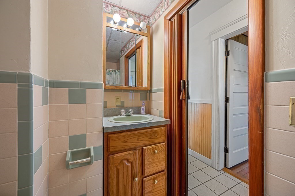 24 Second Street Worcester, MA 01602 - Photo 20 of 42 a bathroom with a granite countertop shower a mirror and a sink