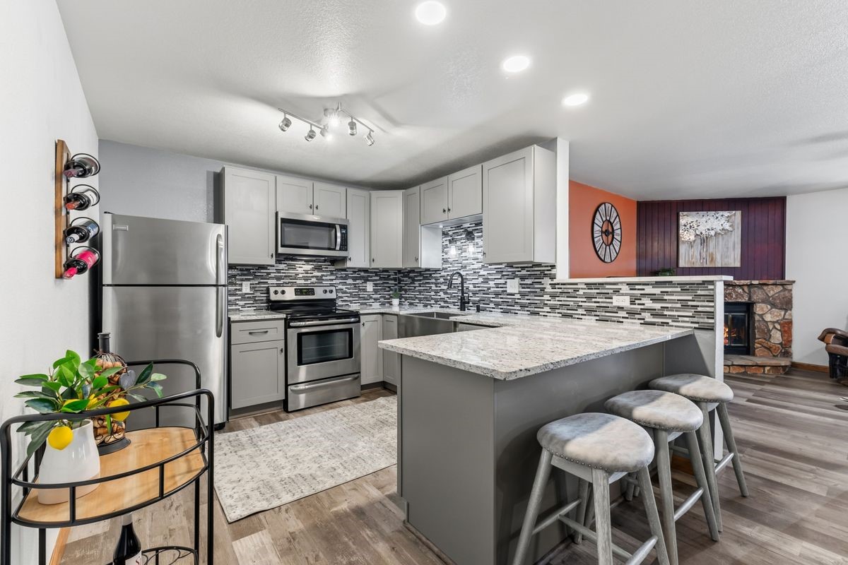 89410 Ryan Gulch Road, Unit 208 Silverthorne, CO 80498 - Photo 1 of 30 a kitchen with cabinets and stainless steel appliances