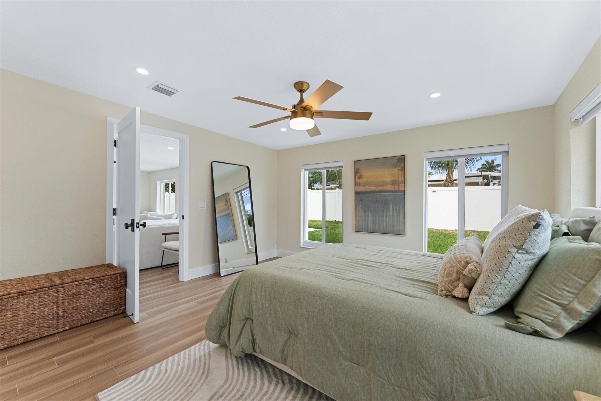 1289 Southwest 7th Street Boca Raton, FL 33486 - Photo 22 of 42 a spacious bedroom with a bed and a chandelier