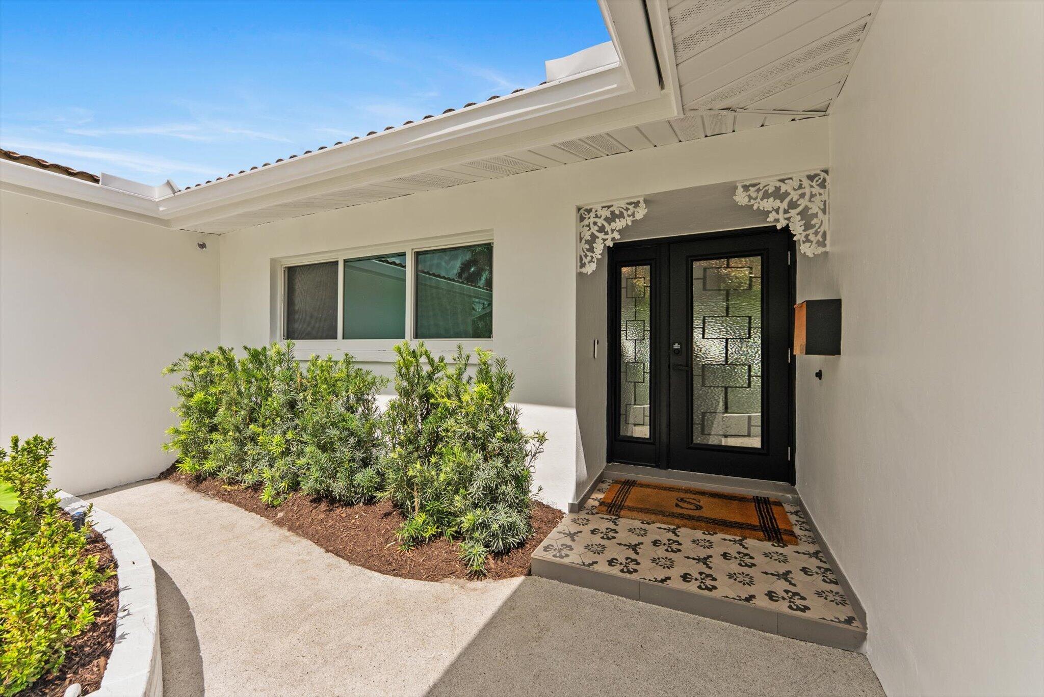 1289 Southwest 7th Street Boca Raton, FL 33486 - Photo 3 of 42 front view of a house with a potted plant