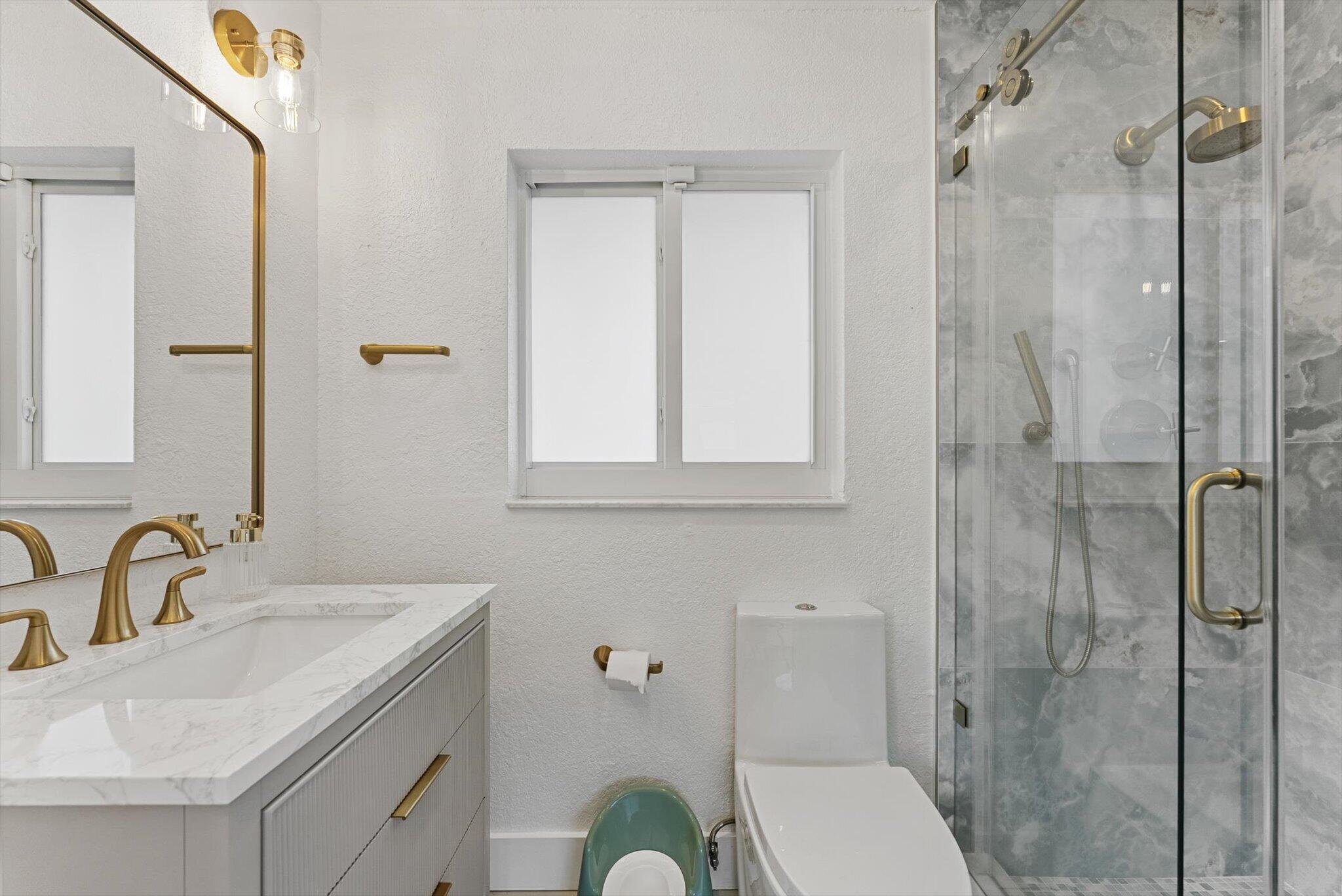 1289 Southwest 7th Street Boca Raton, FL 33486 - Photo 32 of 42 a bathroom with a sink toilet and shower