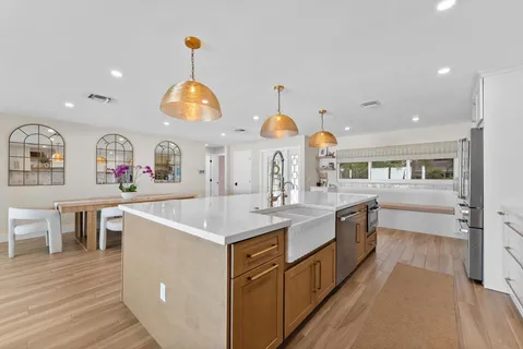 a large kitchen with lot of counter space and wooden floor