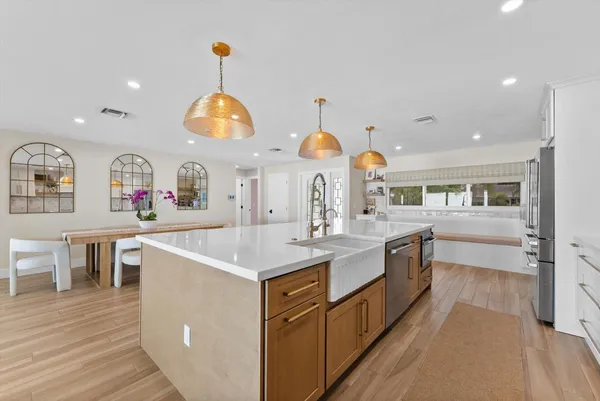 a large kitchen with lot of counter space and wooden floor