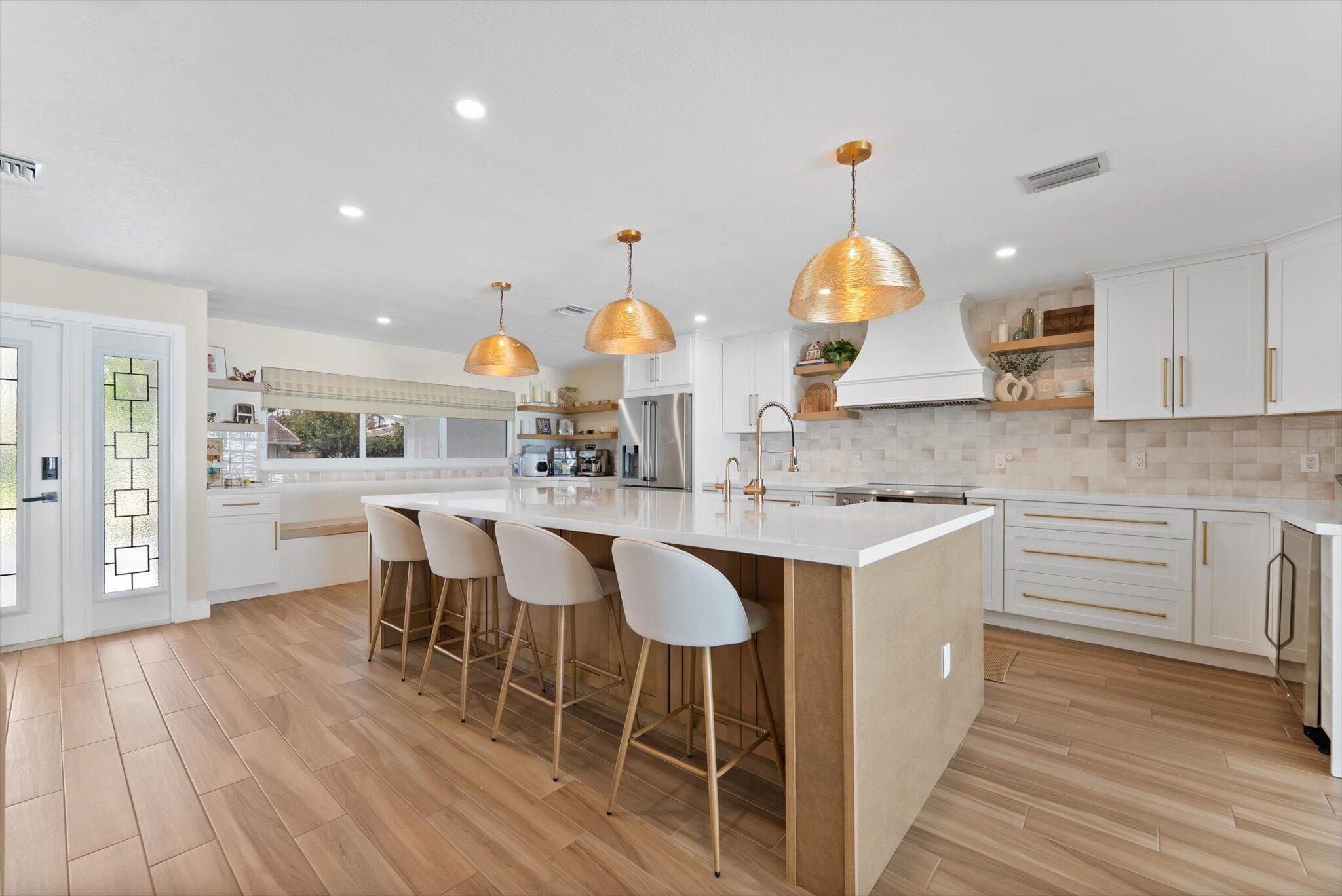 1289 Southwest 7th Street Boca Raton, FL 33486 - Photo 10 of 42 a kitchen with stainless steel appliances granite countertop a sink stove and wooden floor