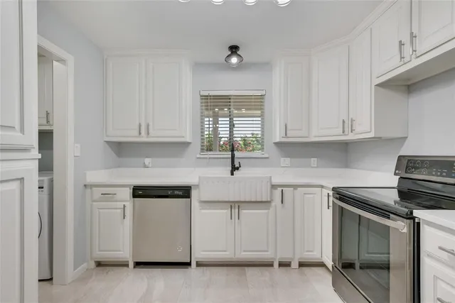 a kitchen with white cabinets and white appliances