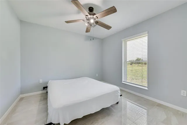 a bed sitting in a bedroom next to a window