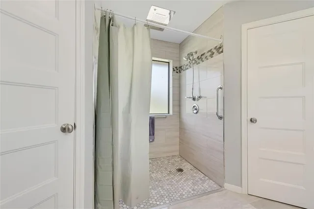 a bathroom with a shower and a glass door