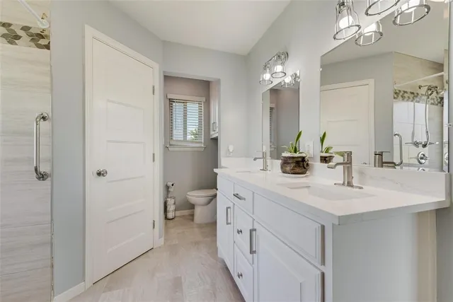 a bathroom with a double vanity sink a mirror and a shower