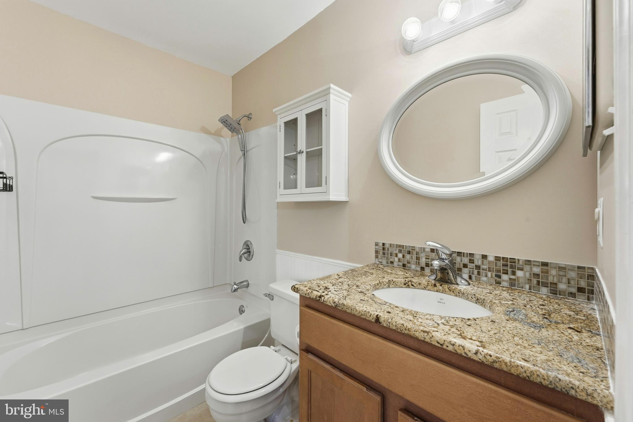 6036 Old Landing Way, Unit 29 Burke, VA 22015 - Photo 20 of 31 a bathroom with a granite countertop sink toilet a mirror and bathtub