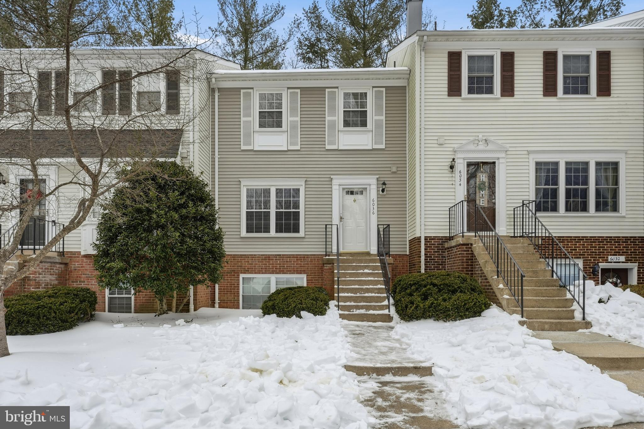6036 Old Landing Way, Unit 29 Burke, VA 22015 - Photo 2 of 31 a front view of a house with a yard covered with snow