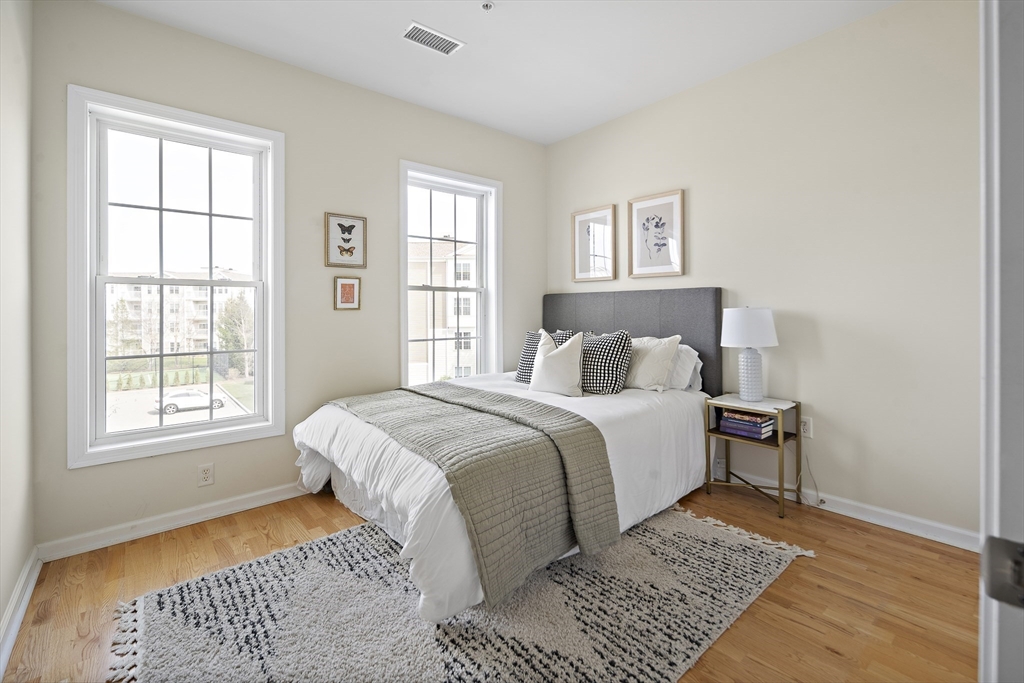 107 Clocktower Drive, Unit 303 Waltham, MA 02452 - Photo 14 of 18 a bedroom with a large bed and a window