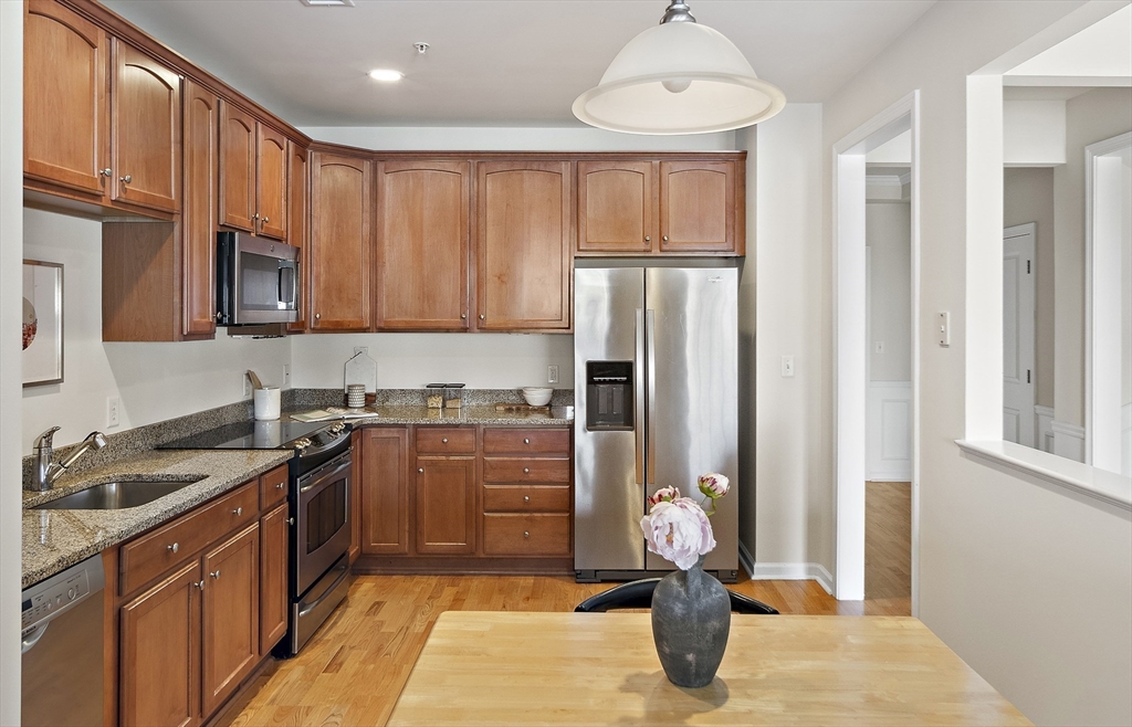 107 Clocktower Drive, Unit 303 Waltham, MA 02452 - Photo 7 of 18 a kitchen with stainless steel appliances granite countertop a refrigerator stove and sink