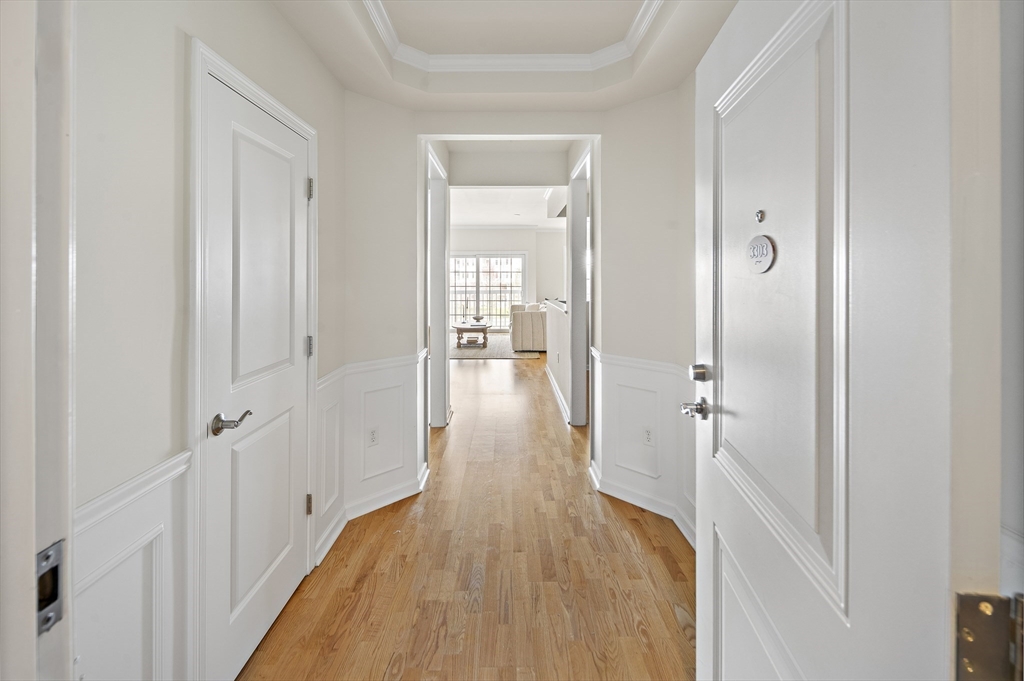107 Clocktower Drive, Unit 303 Waltham, MA 02452 - Photo 8 of 18 a view of a hallway with wooden floor and closet area
