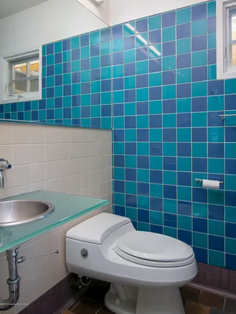 a bathroom with a sink a toilet and a mirror