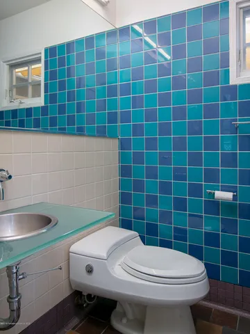 a bathroom with a sink a toilet and a mirror