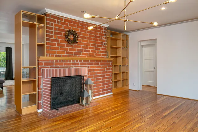 a view of empty room with wooden floor and fireplace