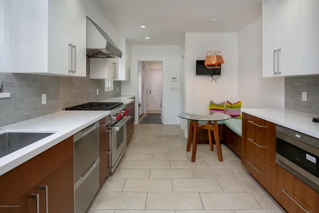 a kitchen with stainless steel appliances a stove a sink and a refrigerator