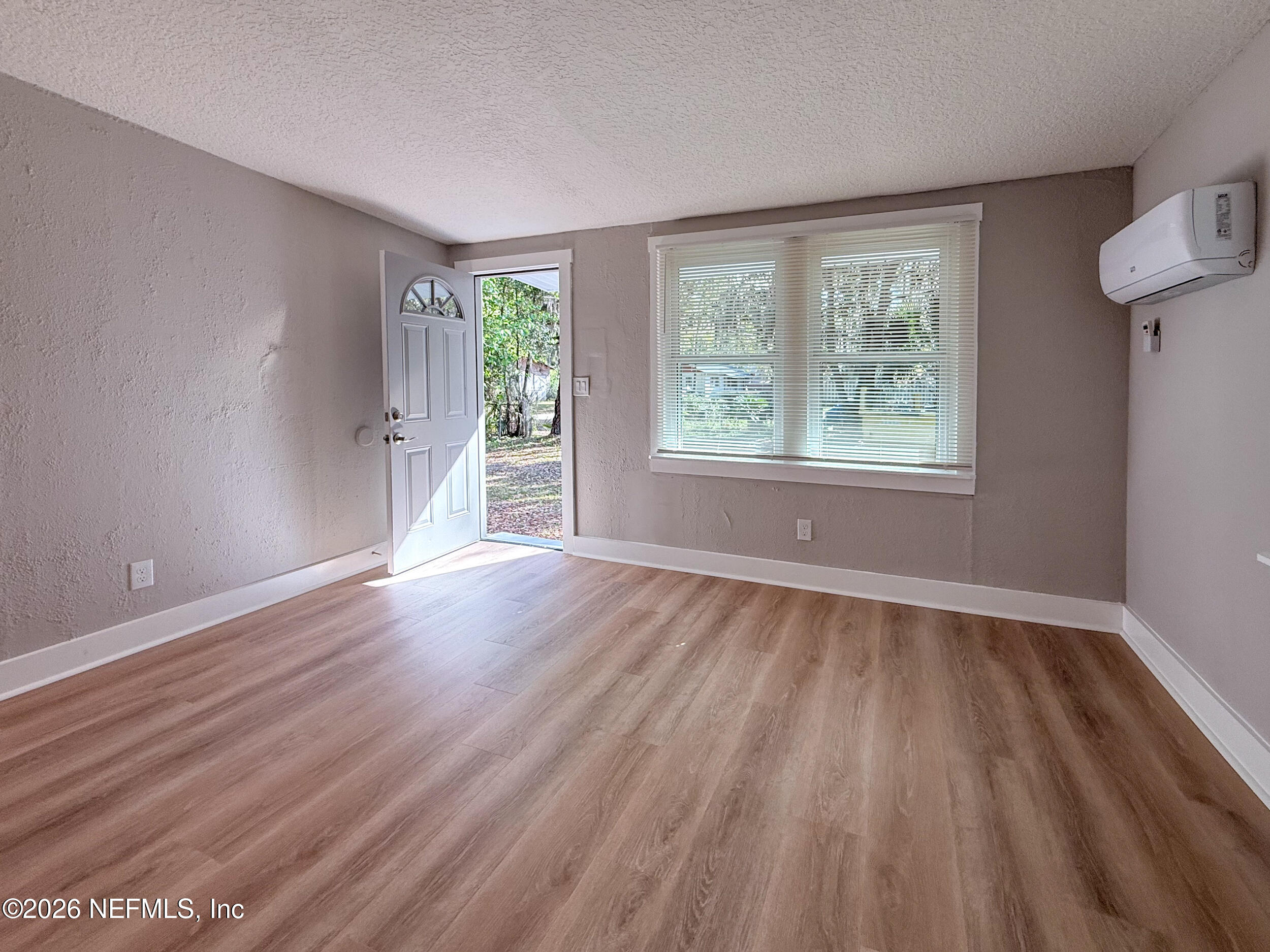 6304 Blanchard Road Jacksonville, FL 32216 - Photo 6 of 15 an empty room with wooden floor and windows