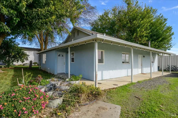 a view of a house with backyard and parking space