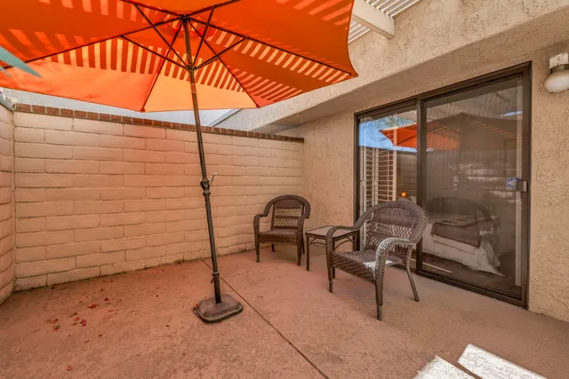 a backyard of a house with barbeque oven table and chairs