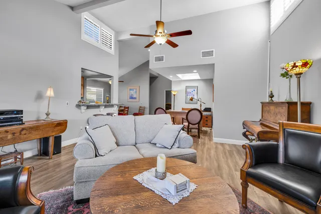 a living room with furniture a ceiling fan and a rug