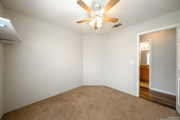 an empty room with fan and a ceiling fan