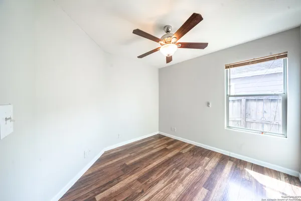 an empty room with closet and ceiling fan