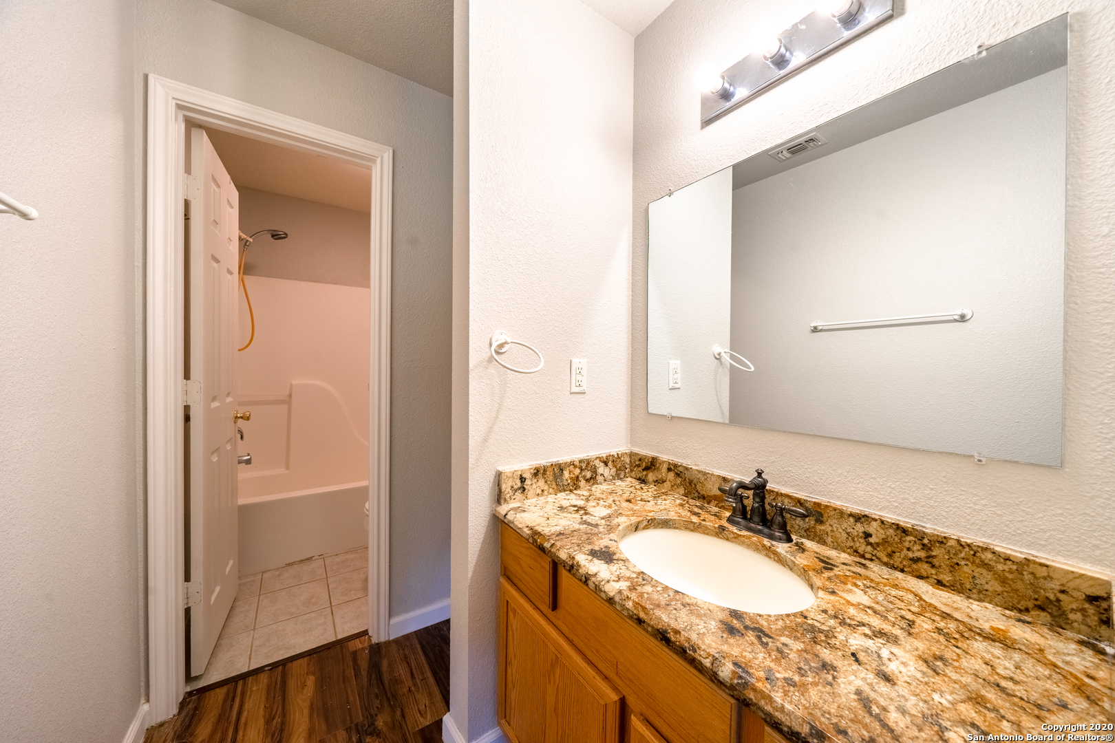7907 M G Road San Antonio, TX 78251 - Photo 19 of 19 a bathroom with a granite countertop sink and a mirror
