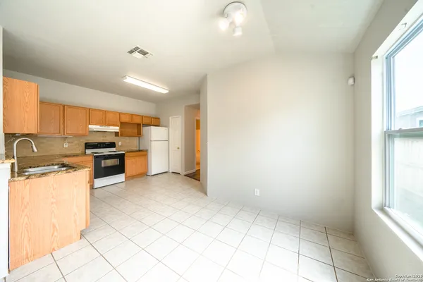 a kitchen with stainless steel appliances granite countertop a stove a sink and a refrigerator